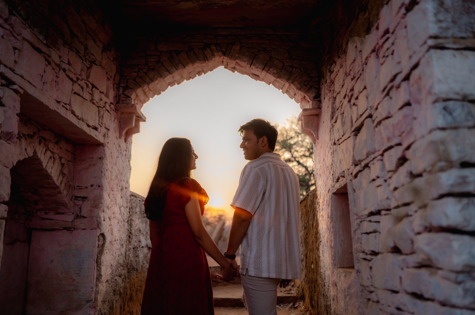 Couple holding hands under a heritage arch